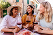 © Xavier Lorenzo - Young happy diverse women friends enjoying time together toasting red wine and eating italian aperitif in a restaurant. Friendship concept.