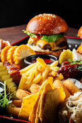 Poster - A close-up of a gourmet burger with fries, nachos, and ribs on a platter, ideal for food-related themes