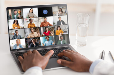 Poster - A persons hands are visible typing on a laptop while a virtual meeting with several participants is displayed on the screen. Experience of virtual communication, collaboration in the modern workplace.