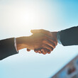 © Penn/peopleimages.com - Business people, city and handshake for property investment, architecture or real estate deal on blue sky. Clients, realtor or investor shaking hands for thank you, success and deal or support below