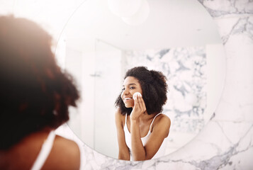 Wall Mural - Black woman, mirror and cotton pad in bathroom for morning routine with natural beauty, skin and glow. Happy girl, reflection and facial lotion or cream in home with dermatology, smile and self care