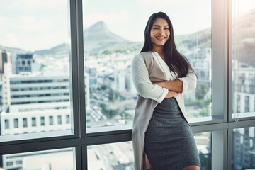 Confidence, office and portrait of happy woman at window, business success or positive in Brazil. Female attorney, arms crossed or smile in agency with pride, career development or ambition in city