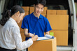 © NINENII - Asian delivery man deliver box parcel package to customer at office, shipping delivery concept.