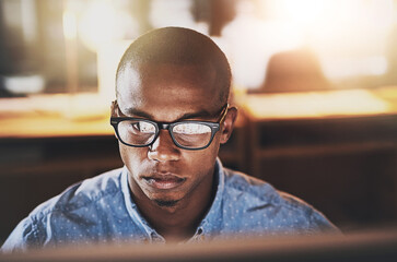Leinwandbilder - Serious businessman, glasses and night with computer for project deadline, design or research at office. Face of young man, designer or employee working late on PC for web development at workplace