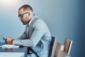Fototapete - Businessman, boardroom and typing with phone for communication, schedule or finance at office. Young man, accountant or employee on mobile smartphone for business proposal, tasks or news at workplace