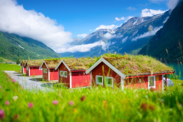 Wall Mural - traditional scandinavian houses with moss on the roof. beautiful mountain lake in norway. nordic jou