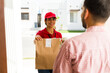 © AntonioDiaz - Happy delivery woman delivering a paper bag of takeout food and drinks to a customer's home