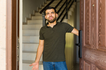 Upset man at home door, looking unhappy about people knocking on his door and disturbing his peace