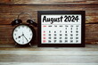 © may1985 - AUGUST 2024 monthly calendar for planning and management concept with alarm clock on wooden background