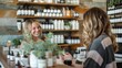 © evgenia_lo - Two white female workers smile and interact at a rustic retail boutique . a salesperson in a natural beauty store explaining the benefits of organic skincare products to a customer
