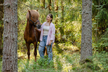 Wall Mural - Woman with Icenlandic horse in forest with sunset on behind