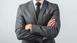 © Kharkovich - A businessman wearing a grey suit stands with his arms crossed