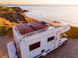 Fototapeta Do przedpokoju - Caravan with solar panels on roof camp on coast, Spain. Aerial view.