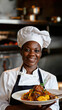 © AnaV - A smiling chef in a white uniform and black apron presents a plate of food. Vertical poster