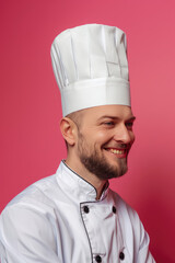 Wall Mural - Chef man smiling on colored background with copy space. Young cook in uniform banner template.