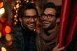 © Vera - Two handsome men with well groomed beards and eyeglasses are smiling and laughing as they open a red curtain together.