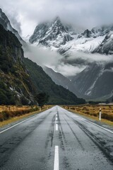 Poster - A serene mountain scene with a long winding road stretching into the distance, flanked by towering peaks