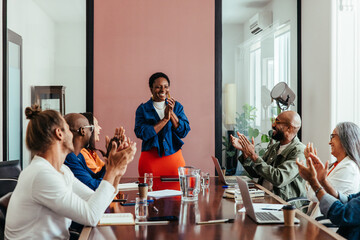 team celebrating achievement with applause in contemporary boardroom