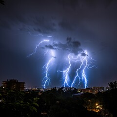 Poster - A group of lightning flashes illuminate the city skyline at night, with buildings and streets below