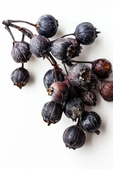 Poster - A cluster of black berries sits on a white surface, perfect for use in food or still life photography