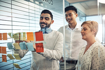 Wall Mural - Sticky note, writing and business people with glass board, brainstorming ideas or teamwork in office. Branding agency, diversity and employees in meeting for planning project, agenda or collaboration