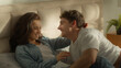 © Yuliia - Man falling on bed woman couple female male tickling laughing bedroom girlfriend boyfriend loving funny together sweetheart enjoy smiling honeymoon affectionate cuddle girl guy weekend home romantic
