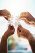 © Penn/peopleimages.com - Business people, hands and puzzle in office with cooperation, problem solving and project management. Employees, jigsaw piece zoom and teamwork for synergy with support, integration and goal strategy
