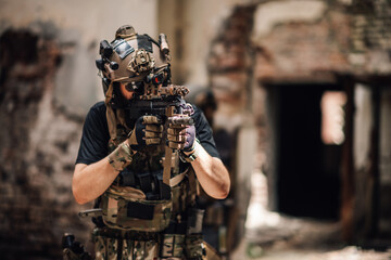 Wall Mural - Portrait of brave soldier in uniform aiming with sniper rifle in ruins