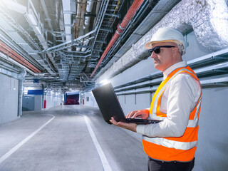 Poster - man engineer. builder in corridor of industrial building. worker inspects engineering tunnel. civil 