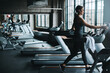 © ReeseArcurs/peopleimages.com - Running, exercise and woman on treadmill in gym listening to music, audio and radio for cardio workout. Sports, wellness and person with earphones for fitness, marathon training and practice for race