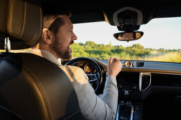 Wall Mural - Man singing in car, view from inside