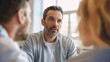 © NiK0StudeO - A man with a beard and gray hair is sitting at a table with two other people