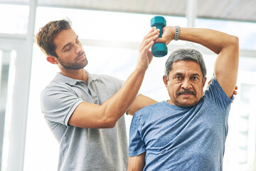 Wall Mural - Elderly man, training and dumbbell with physiotherapist for rehabilitation, wellness and muscle fitness. Senior person, workout and hand weight for management of pain, arthritis and healthy exercise