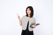 © Jirawatfoto - An Asian woman is holding a tablet and pointing finger to an empty space against a white background.