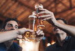 © peopleimages.com - Beer, cheers and hands of friends in pub together for celebration, milestone or social gathering. Alcohol, glass and toast with group of people drinking beverage in bar for bachelor party or bonding