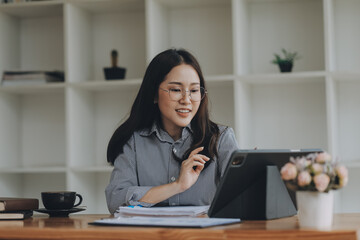 Wall Mural - Portrait of Asian young female working on laptop and financial report at office.