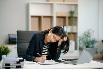 Asian business woman is stressed, bored, and overthinking from working on a tablet