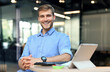 © ty - Portrait of happy man sitting at office desk, looking at camera, smiling