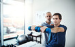 © peopleimages.com - Dumbbell, muscle or strength training and man with physiotherapist in office for appointment. Exercise, fitness or recovery and health professional with physiotherapy patient in rehabilitation clinic