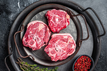 Wall Mural - Raw lamb neck meat with bone on a steel tray. Black background. Top view