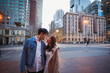 © Austockphoto - Engaged couple embracing in the city with focus on Melbourne cityscape in background at night