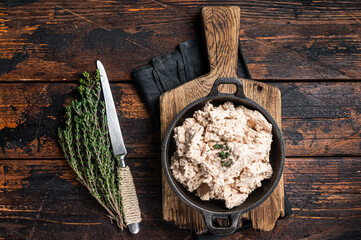 Wall Mural - Cod liver Spread with oil in a skillet. Wooden background. Top view