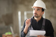 © Antonioguillem - Pensive Construction worker holding clipboard