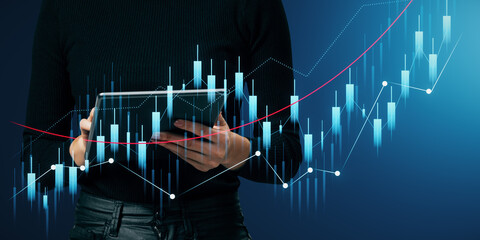 Wall Mural - Close up of female hands using tablet with glowing growing business chart on blurry background. Financial growth and success concept.