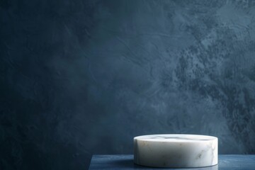 Poster - A white marble pedestal rests on a dark blue surface, illuminated by soft, diffused light