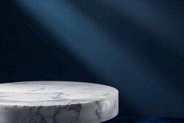 Poster - A white marble pedestal with a smooth, polished surface sits on a dark blue background. Soft, diffused light illuminates the pedestal, creating a subtle highlight on its top