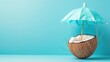 © suratin - Coconut with a turquoise umbrella on a blue background.