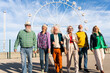 © Westend61 - Retired men and women walking side by side in front of Ferris wheel on sunny day
