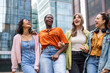 © Westend61 - Happy female friends standing in city