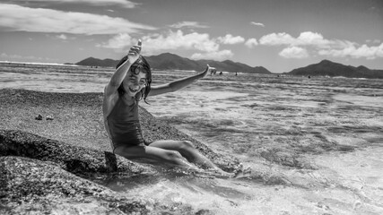 Wall Mural - A very young girl enjoying life at La Digue Island in the Seychelles Archipelago